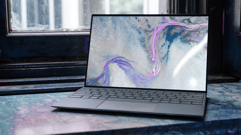Laptop with marbled artwork by a window
